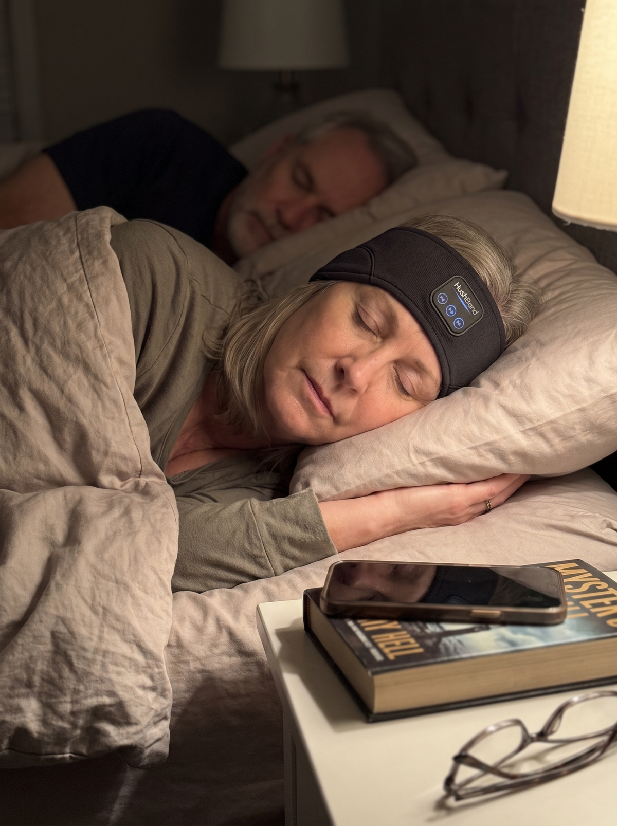 A woman in her late 50s asleep on her side wearing HushBand